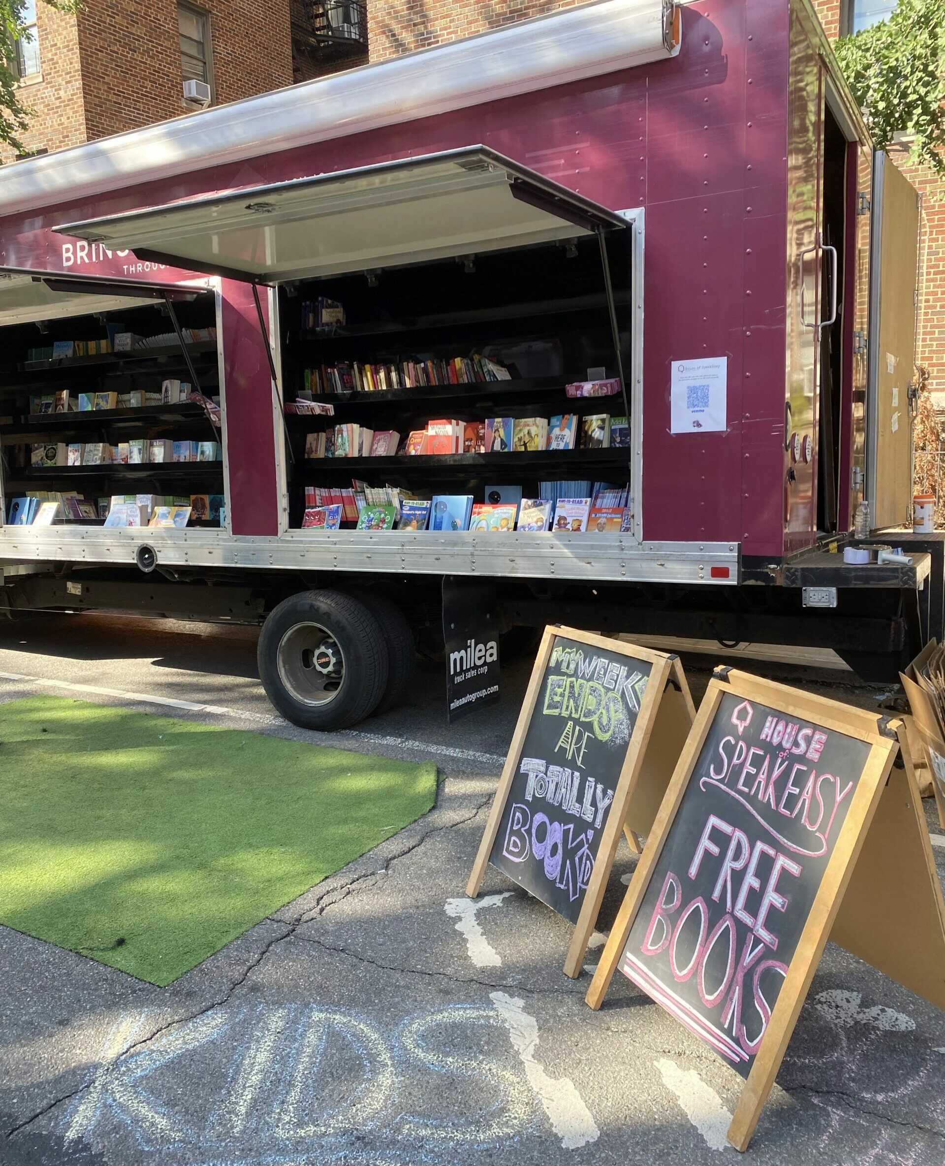 A crowd of young children gathers around House of SpeakEasy's Bookmobile