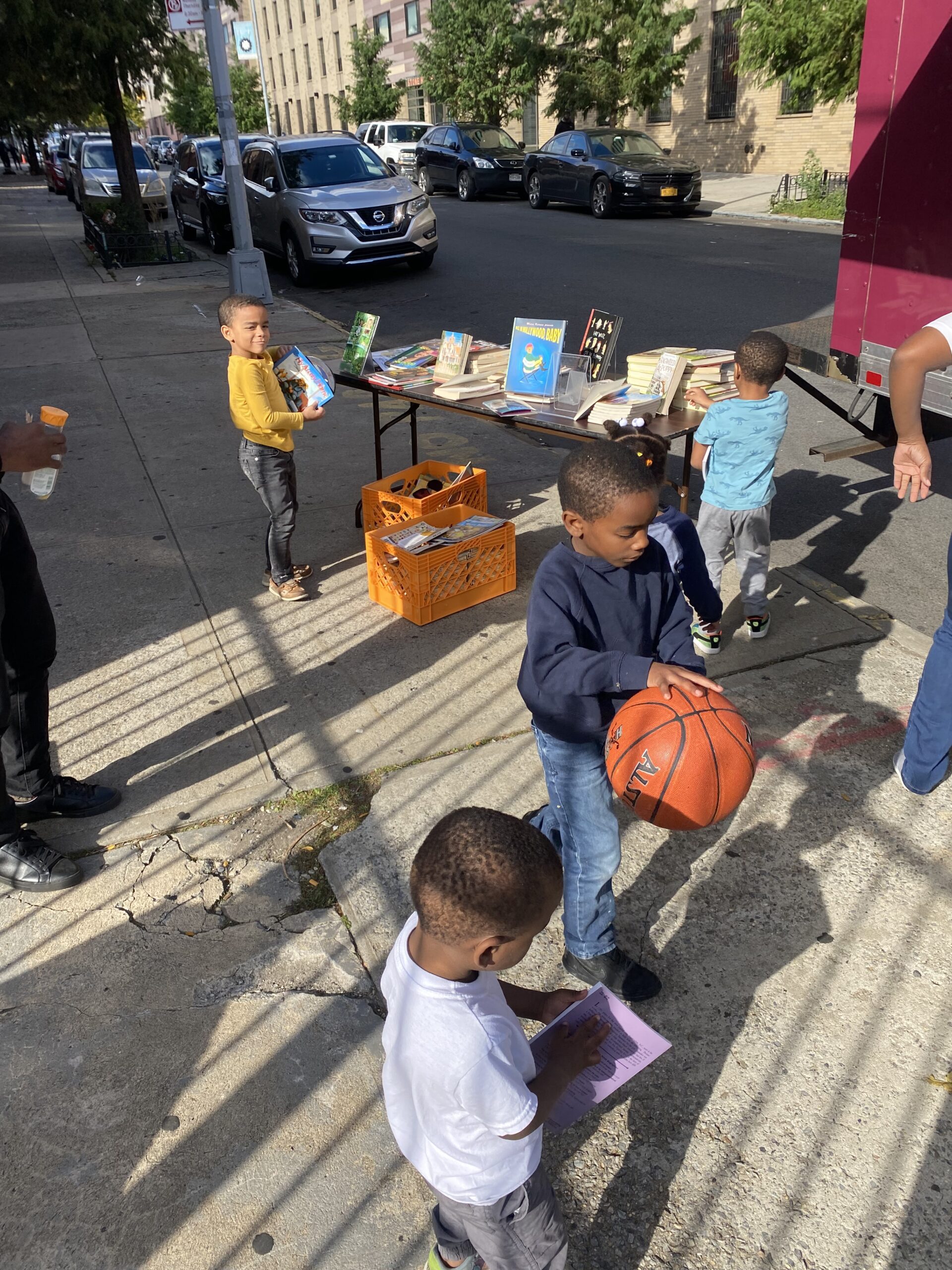 A crowd of young children gathers around House of SpeakEasy's Bookmobile