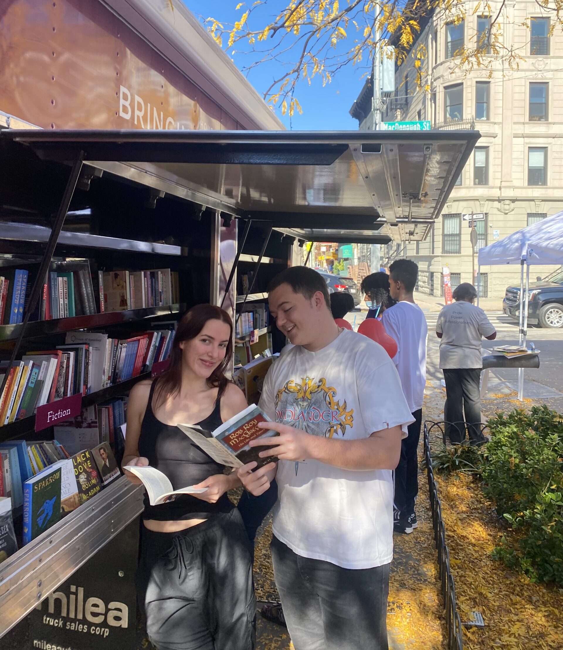 A crowd of young children gathers around House of SpeakEasy's Bookmobile