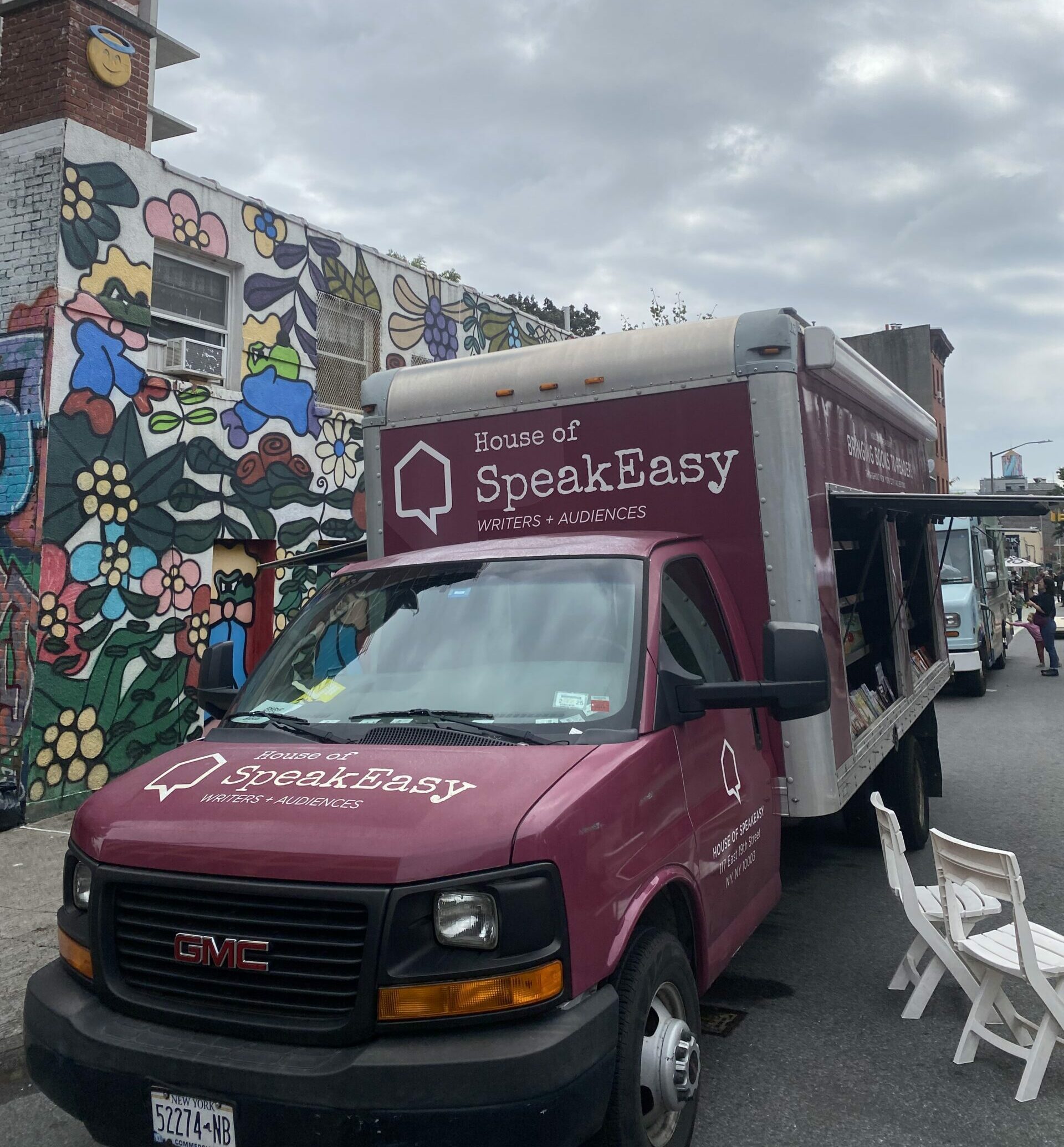 A crowd of young children gathers around House of SpeakEasy's Bookmobile