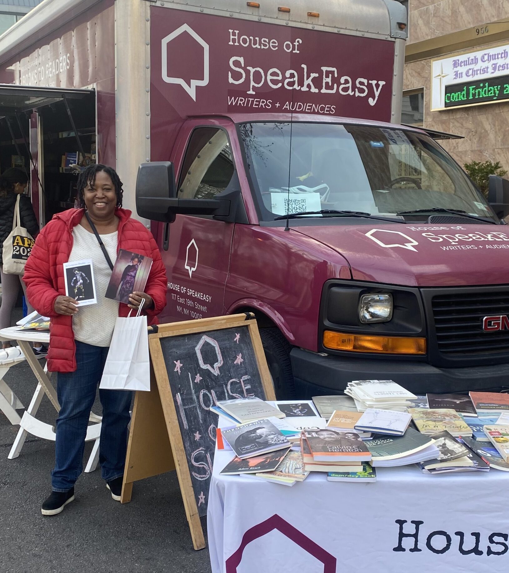 A crowd of young children gathers around House of SpeakEasy's Bookmobile