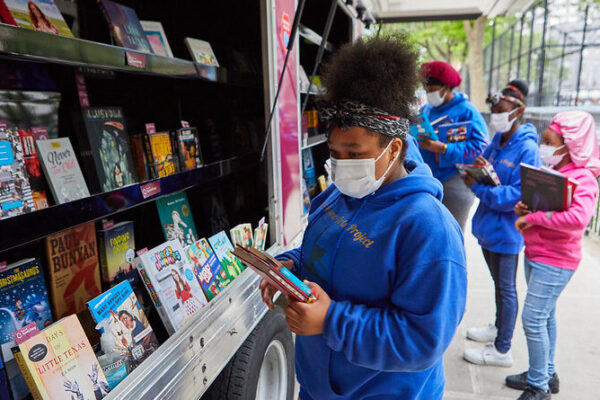 girls look at books in bookmobile