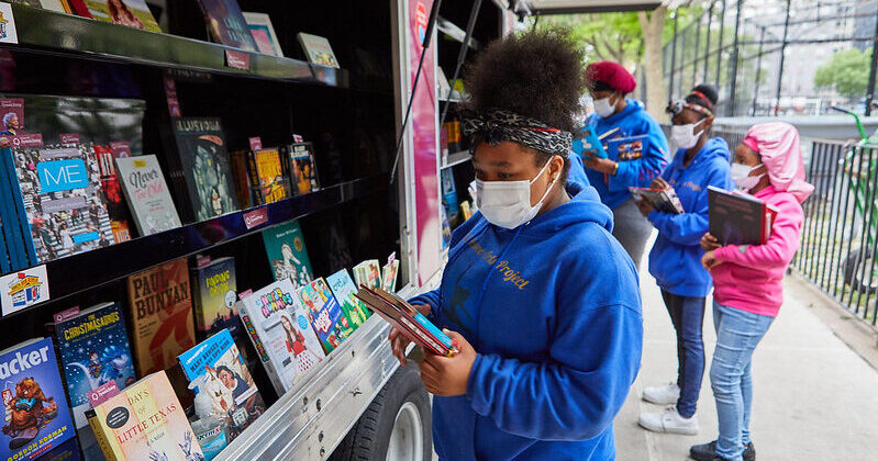 girls look at books in bookmobile