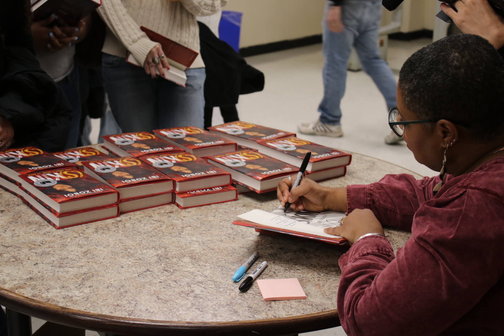 Ibi Zoboi signs copies of S(kin) for students